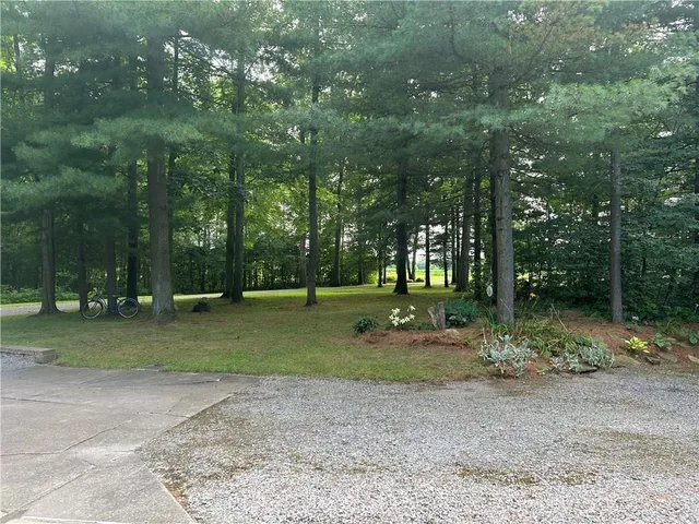 an aerial view of a houses with a yard and lake view