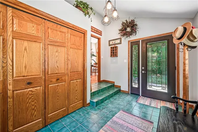 a view of a livingroom with a chandelier wooden floor closet and windows