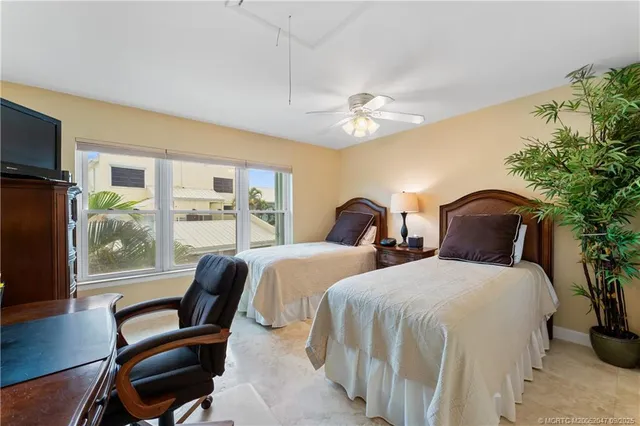 a bedroom with two beds and a large window