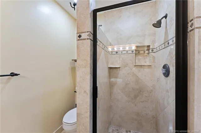 a bathroom with a granite countertop shower and a toilet