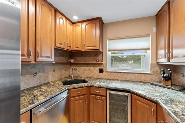 a kitchen with granite countertop wooden cabinets a sink and a window