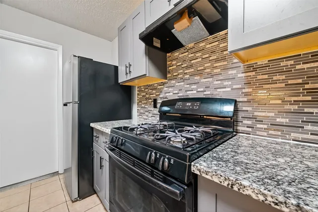 a stove top oven sitting inside of a kitchen