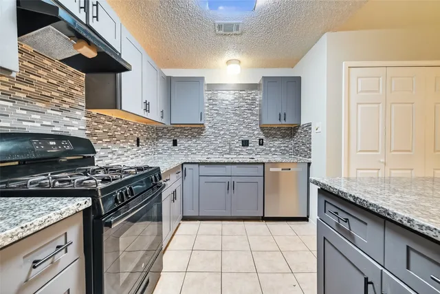 a kitchen with stainless steel appliances granite countertop a stove sink and cabinets