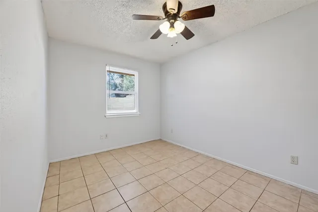 an empty room with chandelier fan