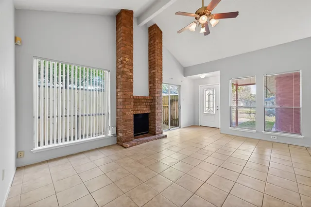 a view of an empty room with a fireplace and a window