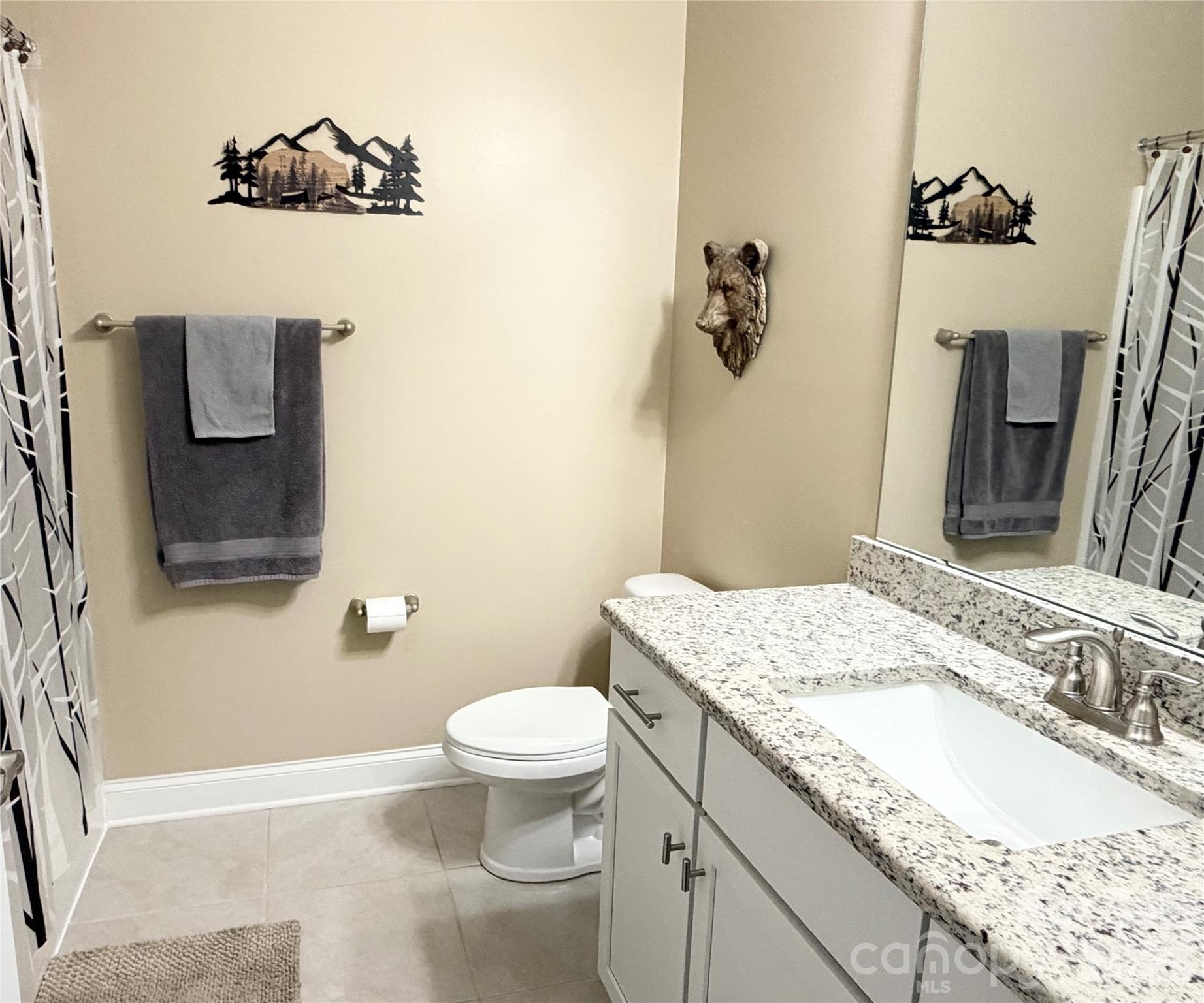 144 Sugar Hill Road Troutman, NC 28166 - Photo 13 of 18 a bathroom with a granite countertop sink a toilet and a mirror