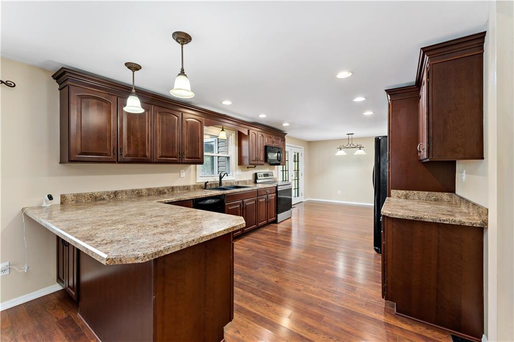 1523 Hastings Mill Road Pittsburgh, PA 15241 - Photo 11 of 50 a kitchen with granite countertop a stove a sink dishwasher and a microwave oven with wooden floor