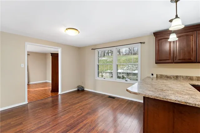 a view of a room with wooden floor and a window