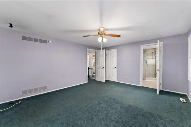 an empty room with a ceiling fan and a window
