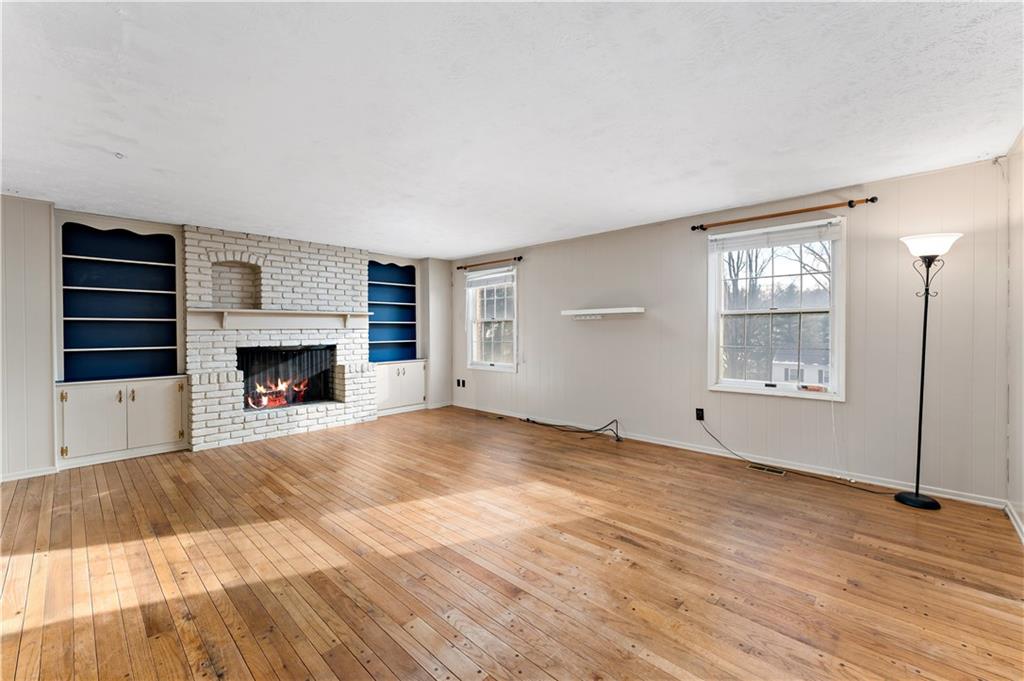 1523 Hastings Mill Road Pittsburgh, PA 15241 - Photo 3 of 50 a view of an empty room with wooden floor fireplace and a window