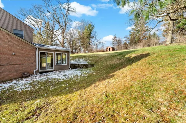 a view of a house with a yard patio and fire pit