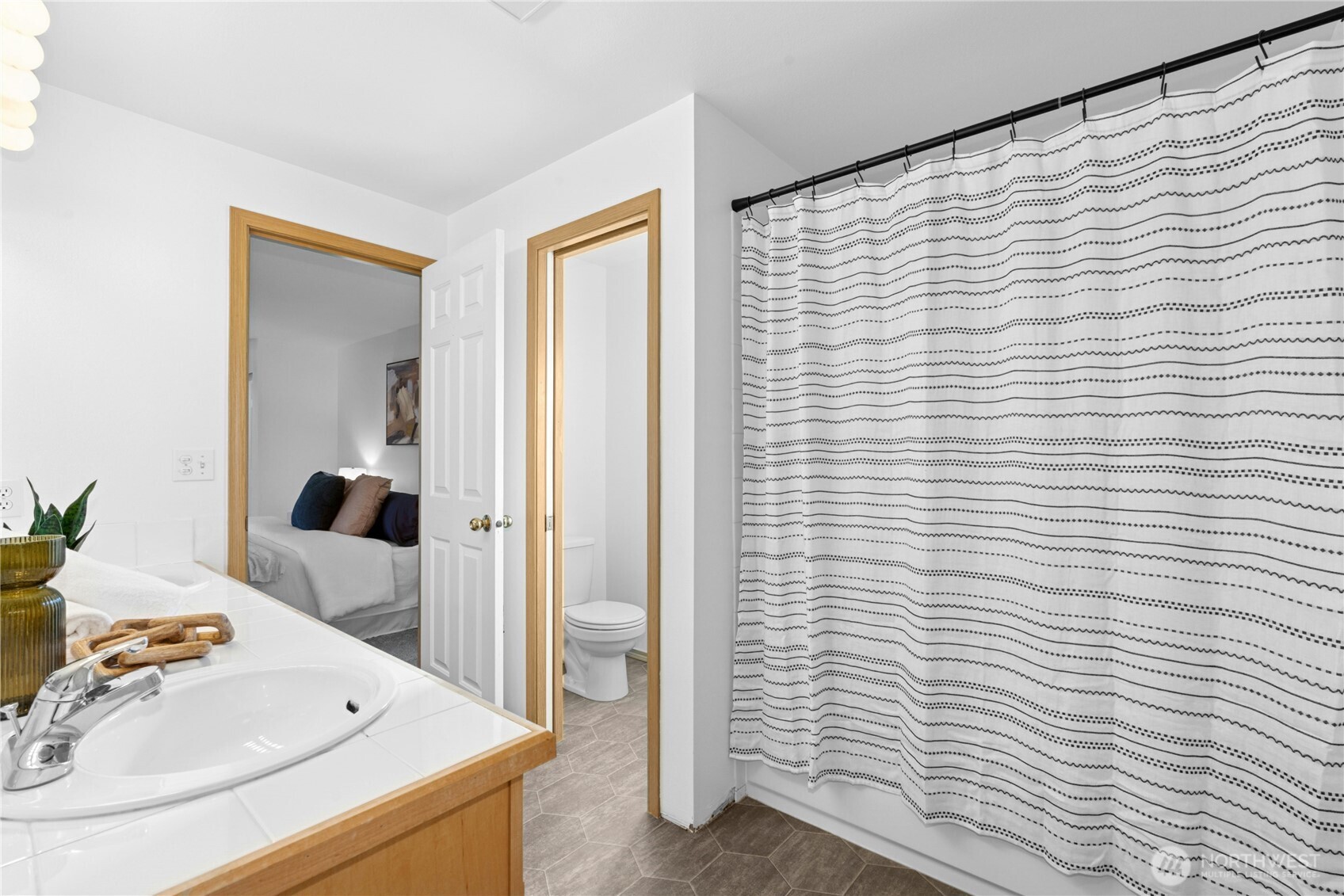 14348 Wallingford Avenue North Seattle, WA 98133 - Photo 17 of 28 a bathroom with a sink a mirror and shower curtain