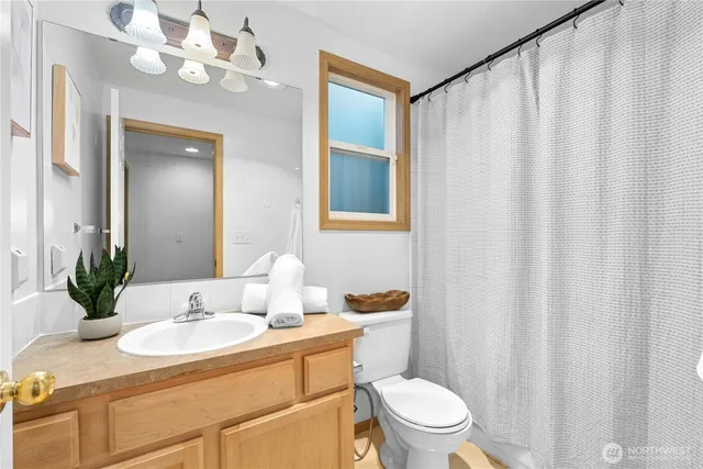 a bathroom with a sink vanity mirror and toilet