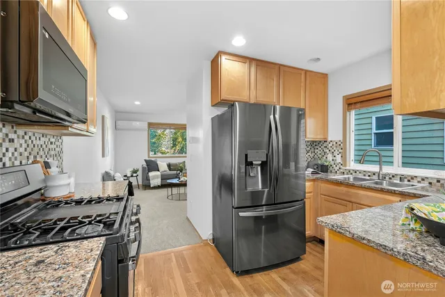 a kitchen with granite countertop a refrigerator stove and sink