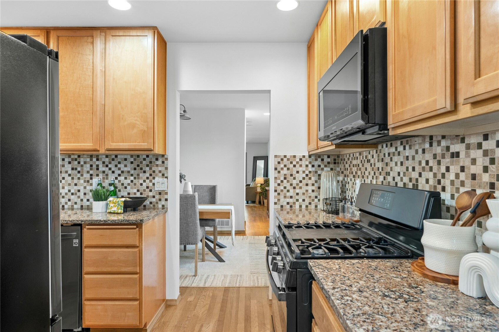14348 Wallingford Avenue North Seattle, WA 98133 - Photo 8 of 28 a kitchen with a stove and a wooden floor