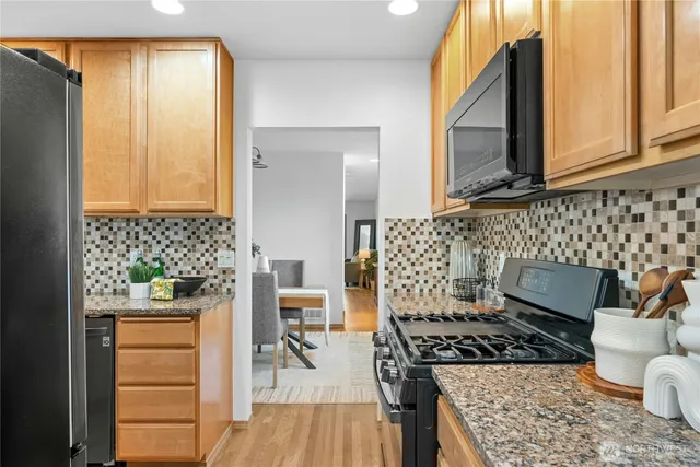 a kitchen with a stove and a wooden floor