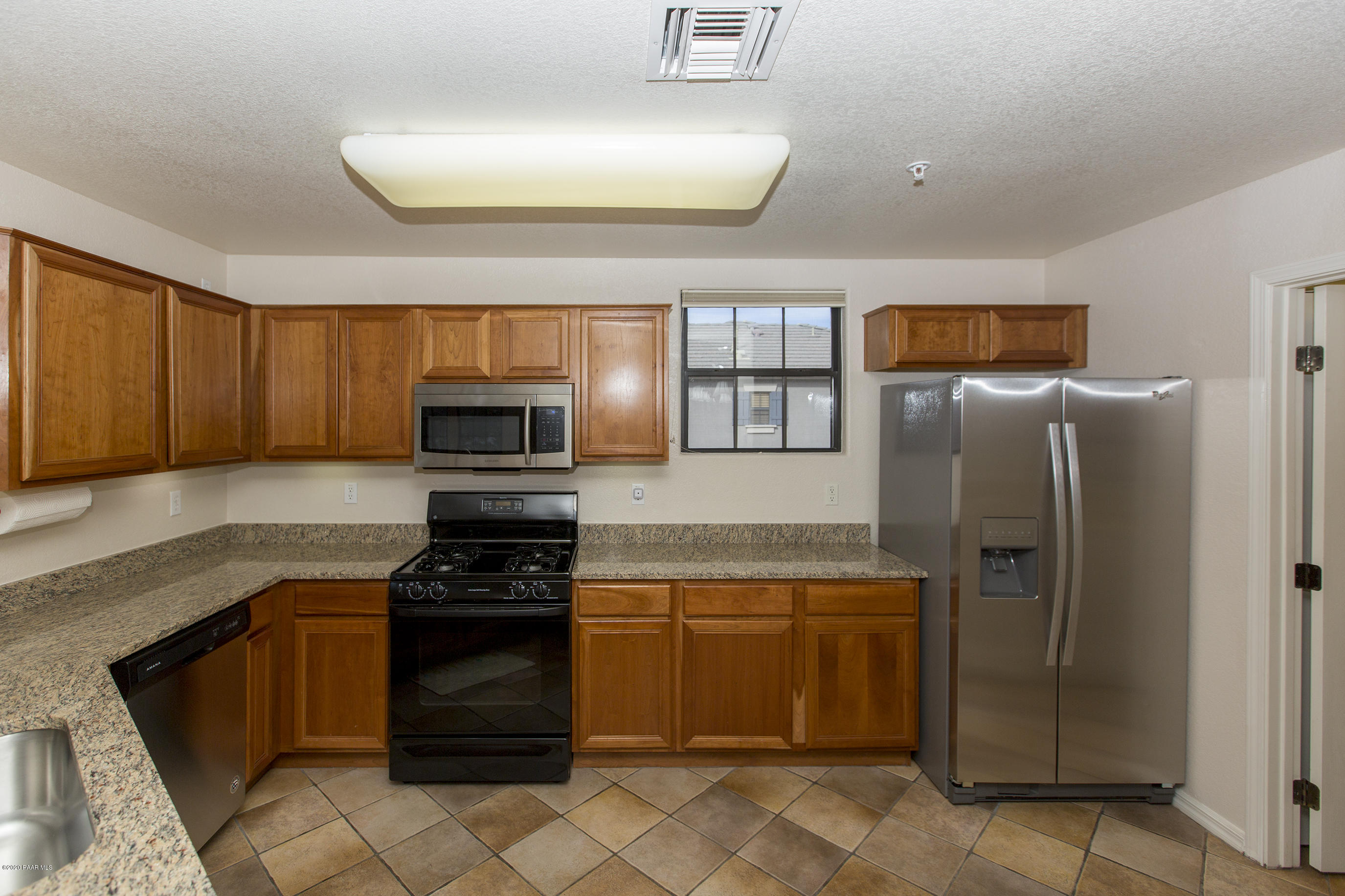 1716 Alpine Meadows Lane, Unit 403 Prescott, AZ 86303 - Photo 11 of 39 a kitchen with granite countertop a refrigerator and a stove top oven