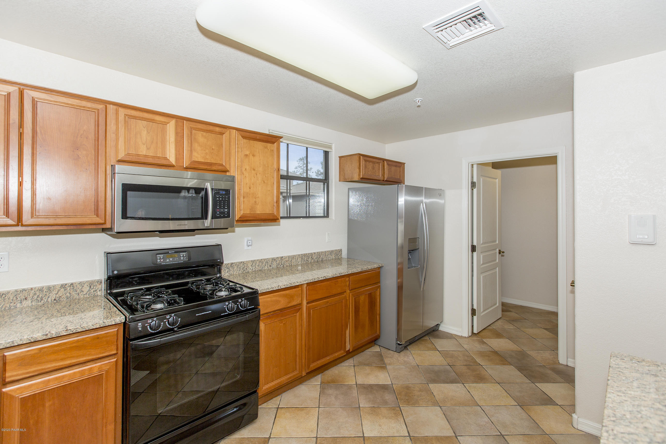 1716 Alpine Meadows Lane, Unit 403 Prescott, AZ 86303 - Photo 12 of 39 a kitchen with stainless steel appliances granite countertop a stove a refrigerator and a microwave
