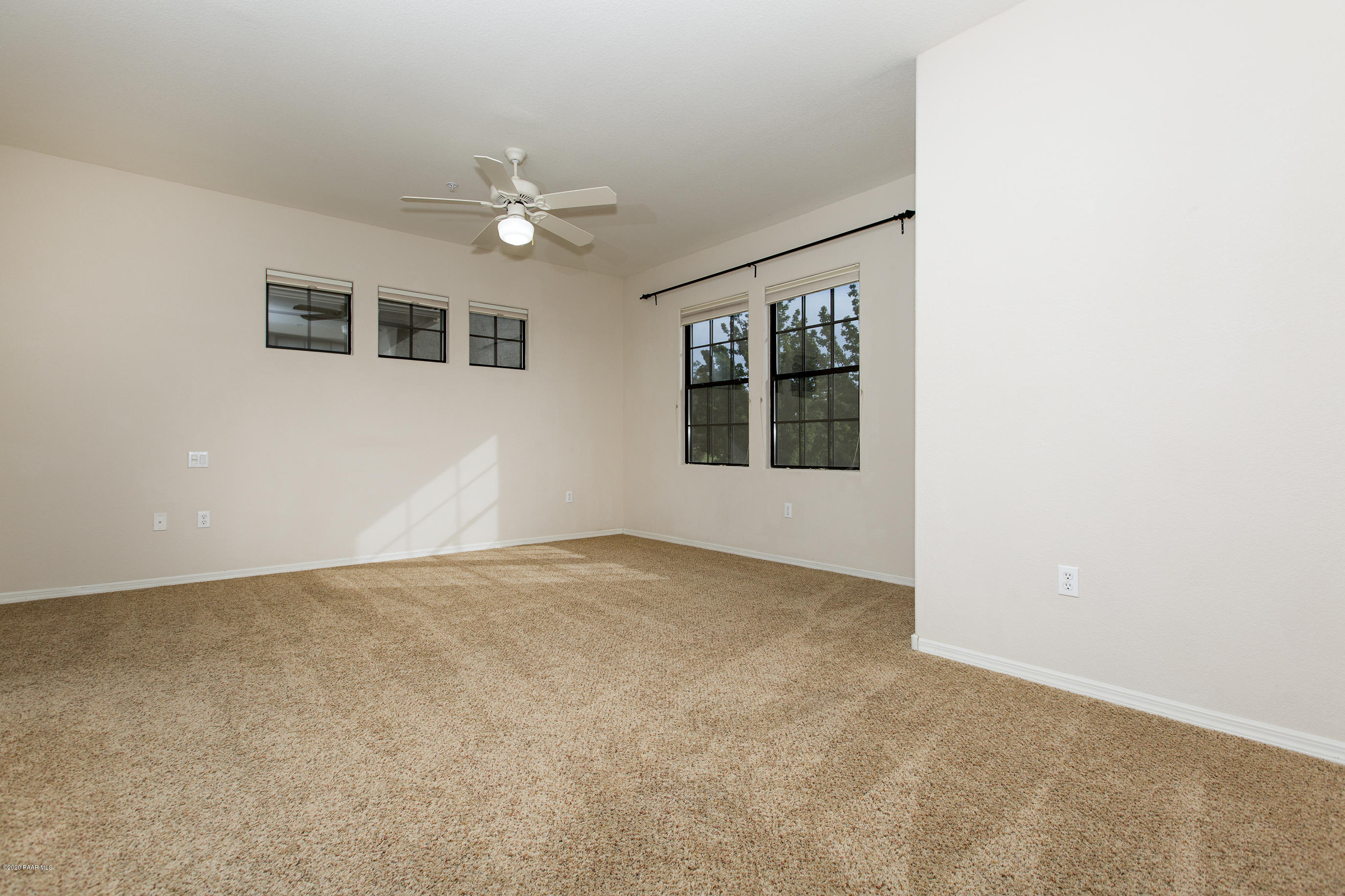 1716 Alpine Meadows Lane, Unit 403 Prescott, AZ 86303 - Photo 14 of 39 an empty room with windows and ceiling fan
