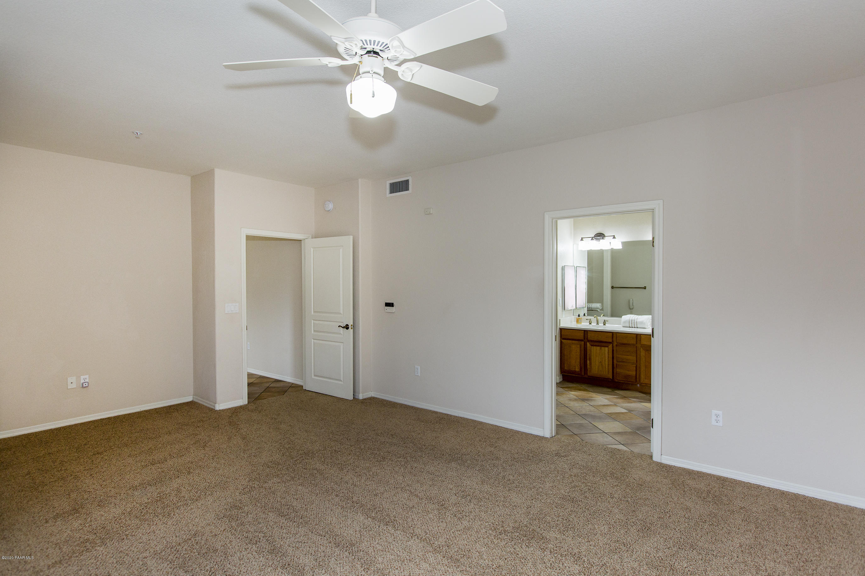 1716 Alpine Meadows Lane, Unit 403 Prescott, AZ 86303 - Photo 15 of 39 an empty room with a ceiling fan and a bathroom