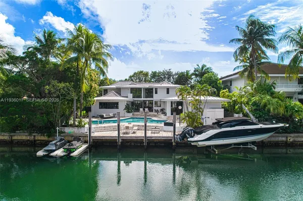 a view of house with swimming pool and yard
