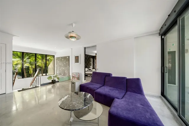 a patio with table and chairs and potted plants
