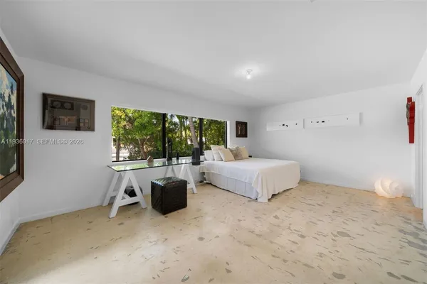 a large bedroom with a bed and glass wall