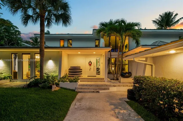 a view of a house with a big yard and large trees