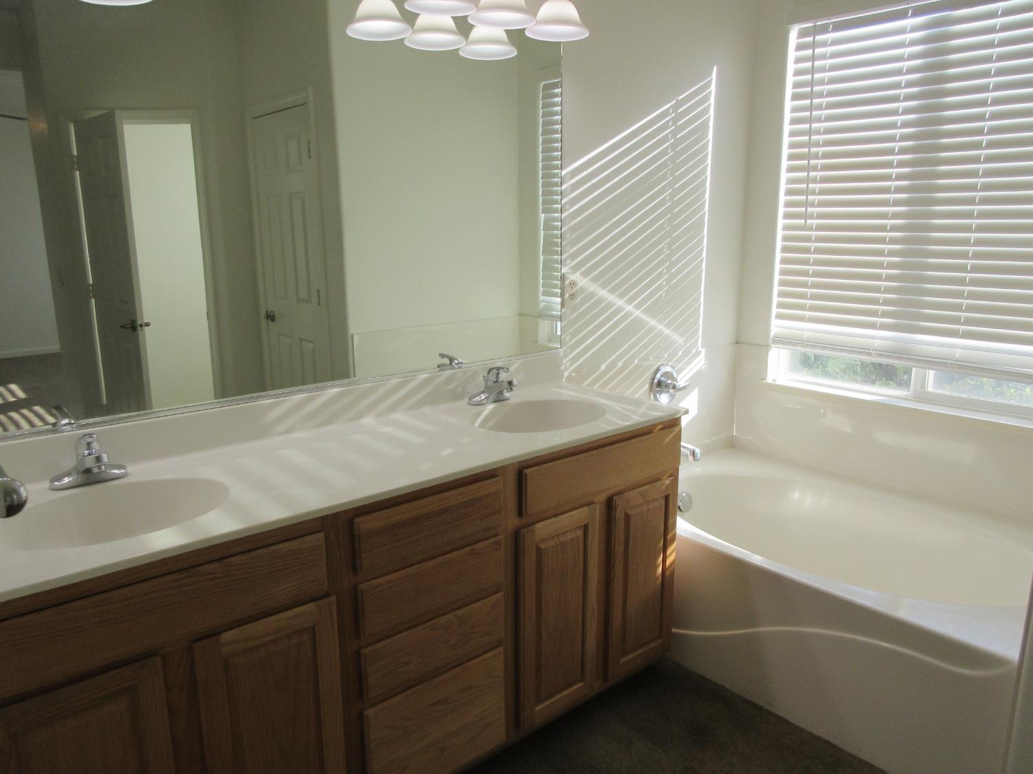 1016 Papaya Street Madera, CA 93638 - Photo 20 of 29 a bathroom with a tub sink and mirror