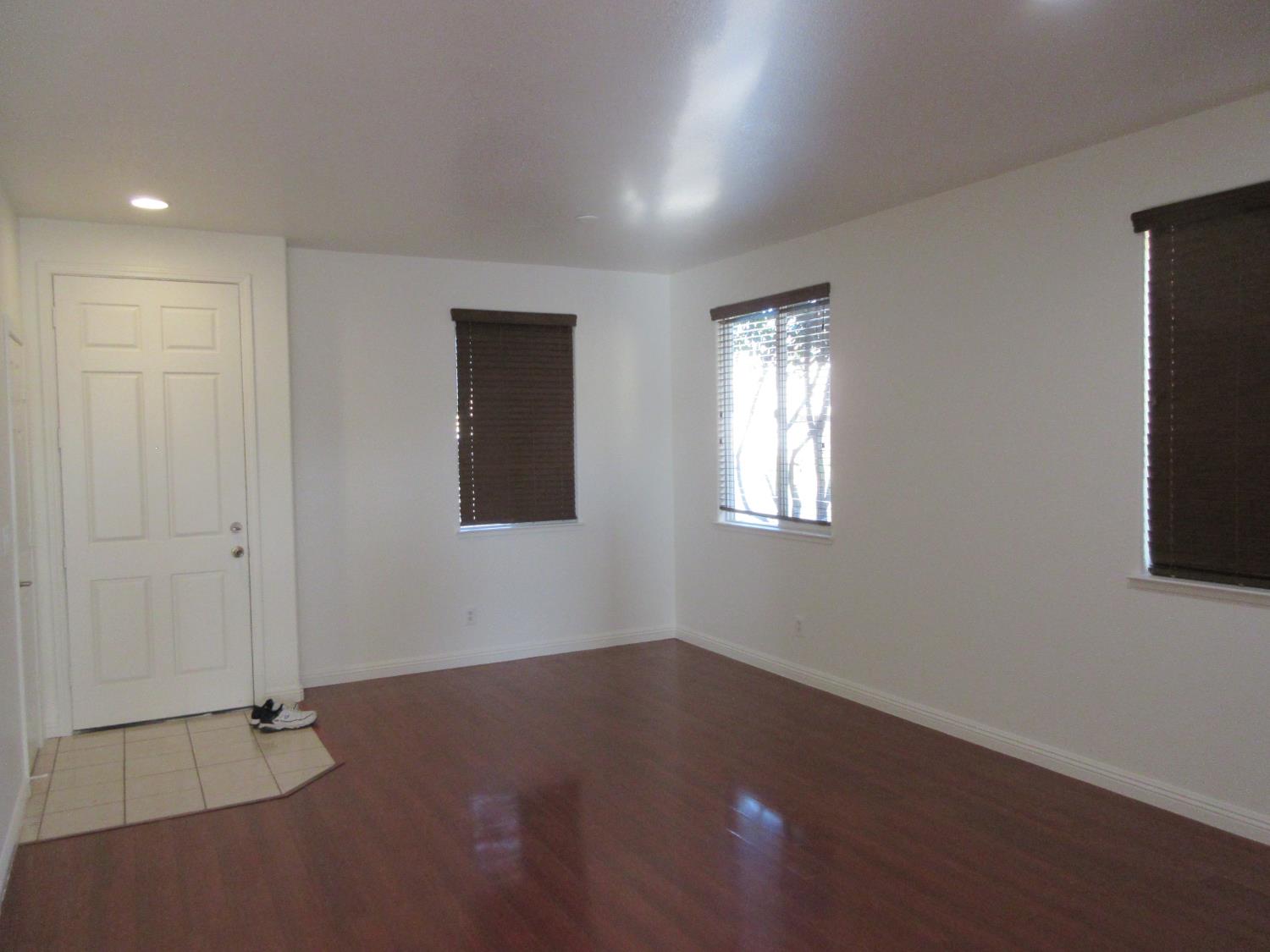1016 Papaya Street Madera, CA 93638 - Photo 5 of 29 a view of an empty room with wooden floor and a window