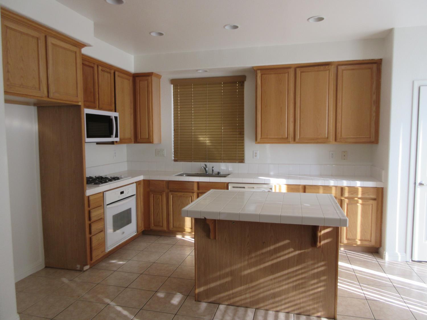 1016 Papaya Street Madera, CA 93638 - Photo 7 of 29 a kitchen with stainless steel appliances granite countertop a sink stove and microwave