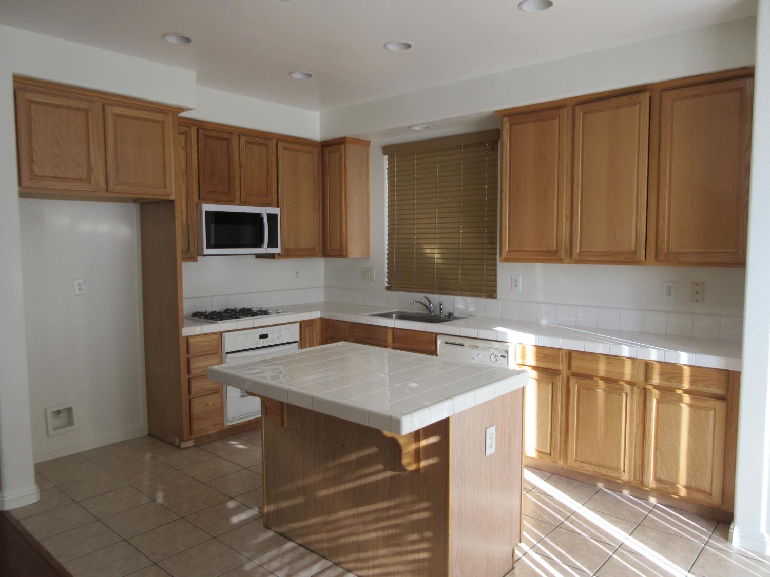 1016 Papaya Street Madera, CA 93638 - Photo 8 of 29 a kitchen with a sink stove and microwave