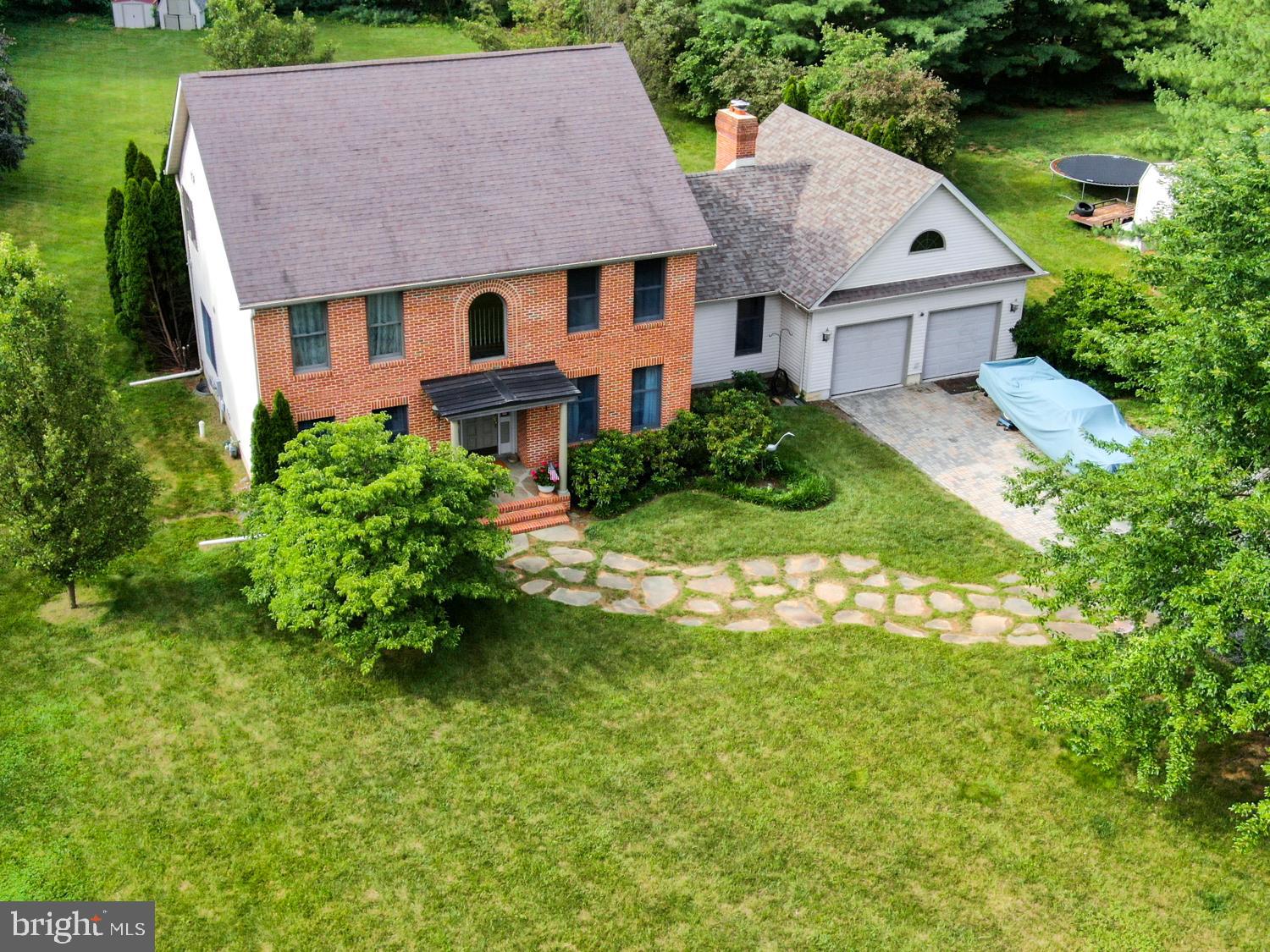 a aerial view of a house next to a big yard and large trees