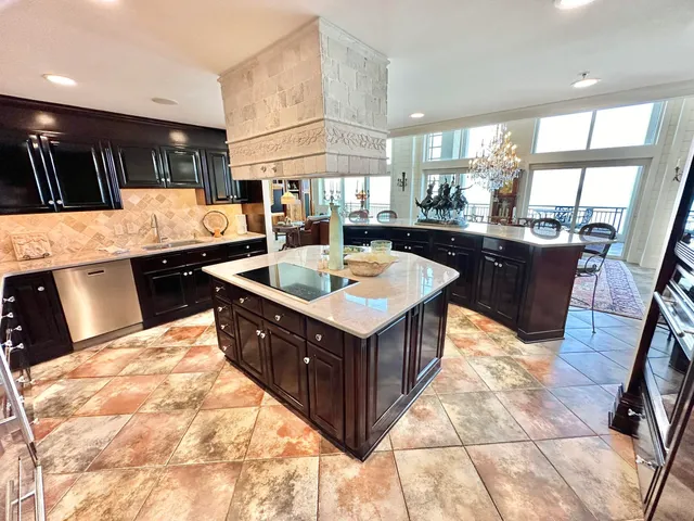 a living room with furniture kitchen view and a chandelier