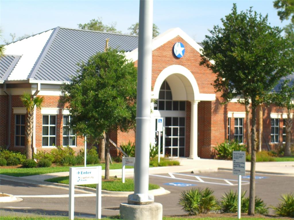 7154 Broad Street Brooksville, FL 34601 - Photo 4 of 8 a view of a white house with a yard and plants next to a road
