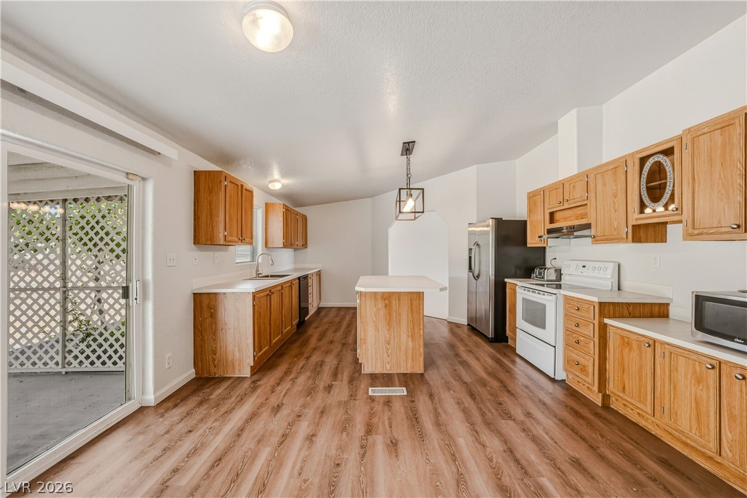 1890 West Dyer Road Pahrump, NV 89048 - Photo 18 of 40 This bright kitchen features wood cabinetry, modern appliances, and convenient access to the outdoors.