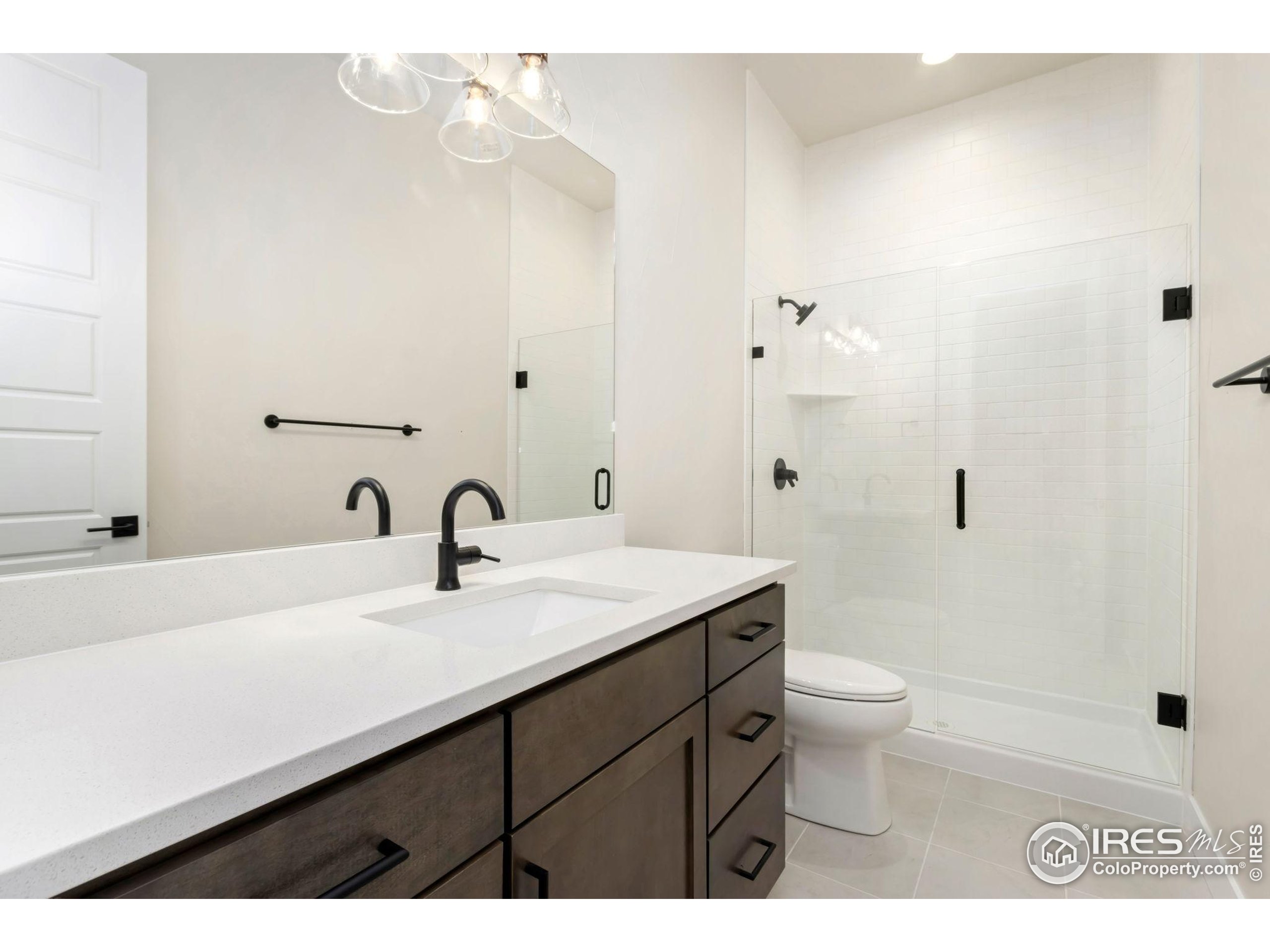 1889 Spring Bloom Drive Windsor, CO 80550 - Photo 15 of 32 a bathroom with a sink a toilet and a mirror