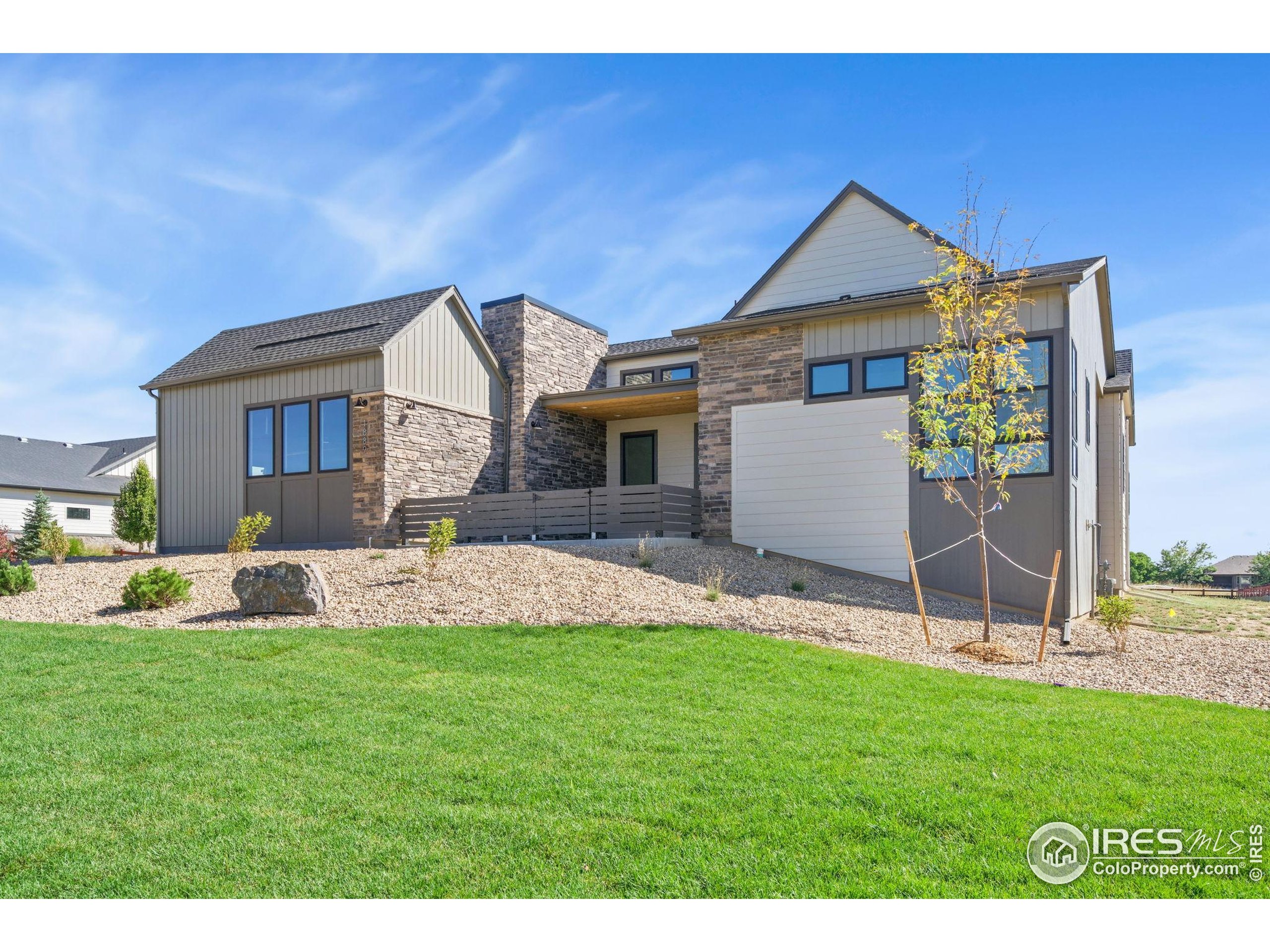 1889 Spring Bloom Drive Windsor, CO 80550 - Photo 20 of 32 a front view of a house with a yard and garage