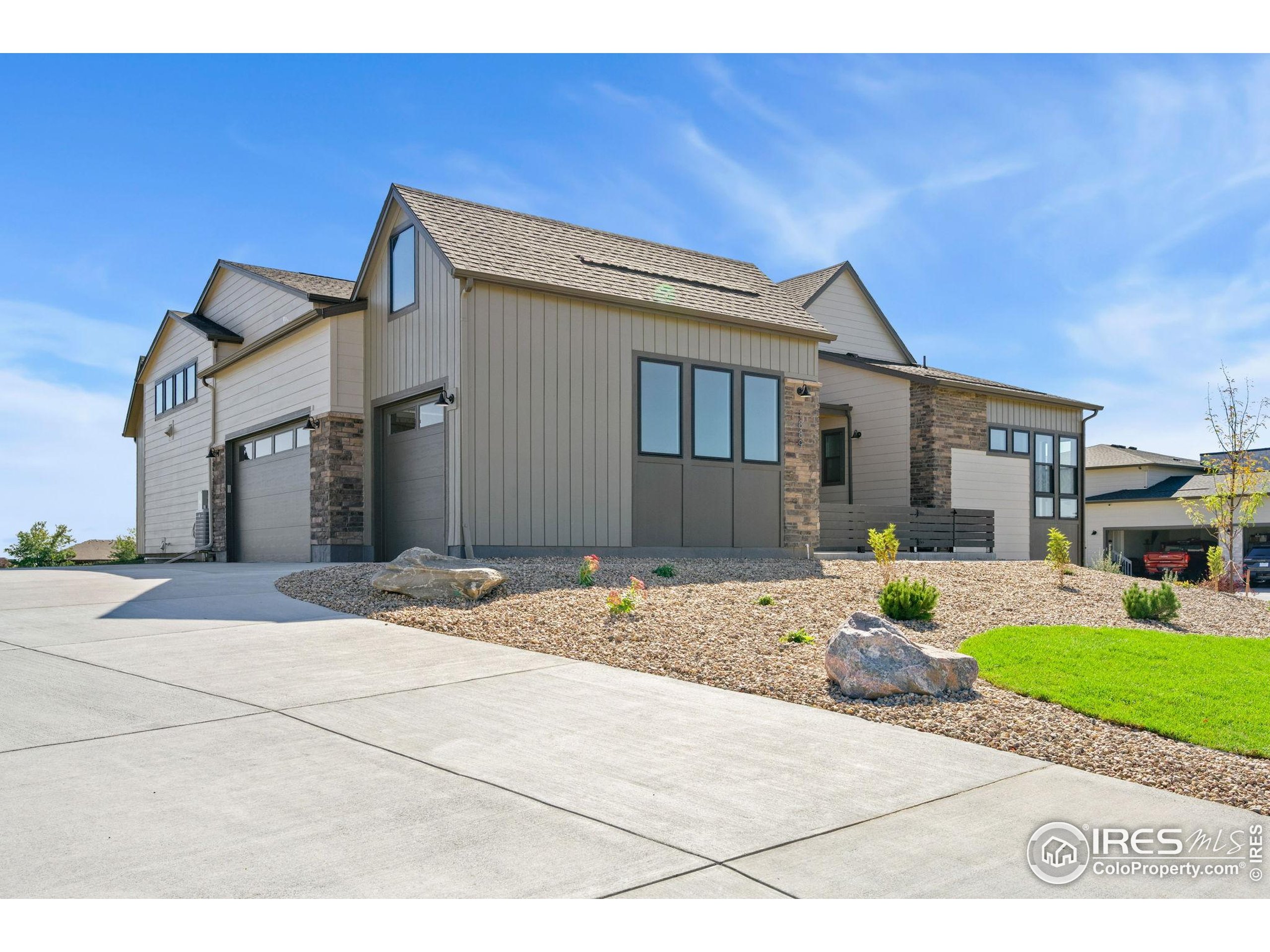 1889 Spring Bloom Drive Windsor, CO 80550 - Photo 3 of 32 a front view of a house with a yard and potted plants