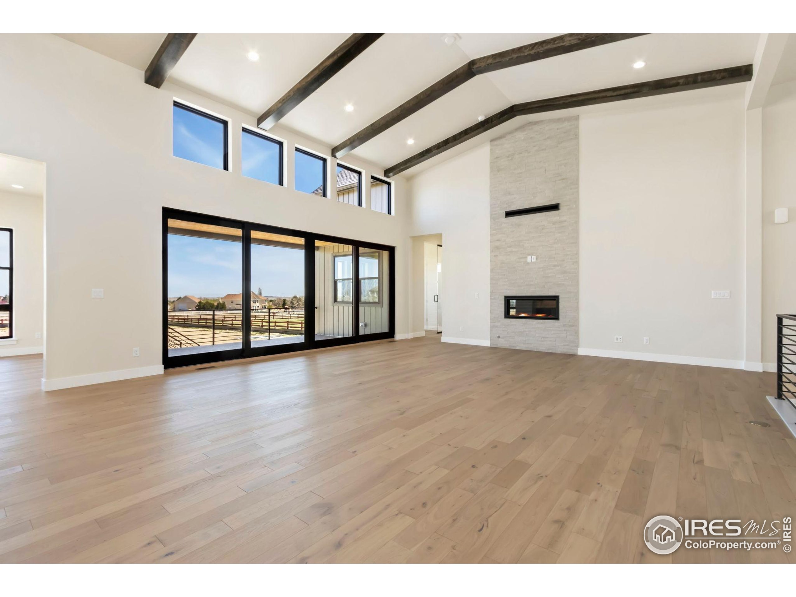 1889 Spring Bloom Drive Windsor, CO 80550 - Photo 4 of 32 a view of an empty room with window and wooden floor