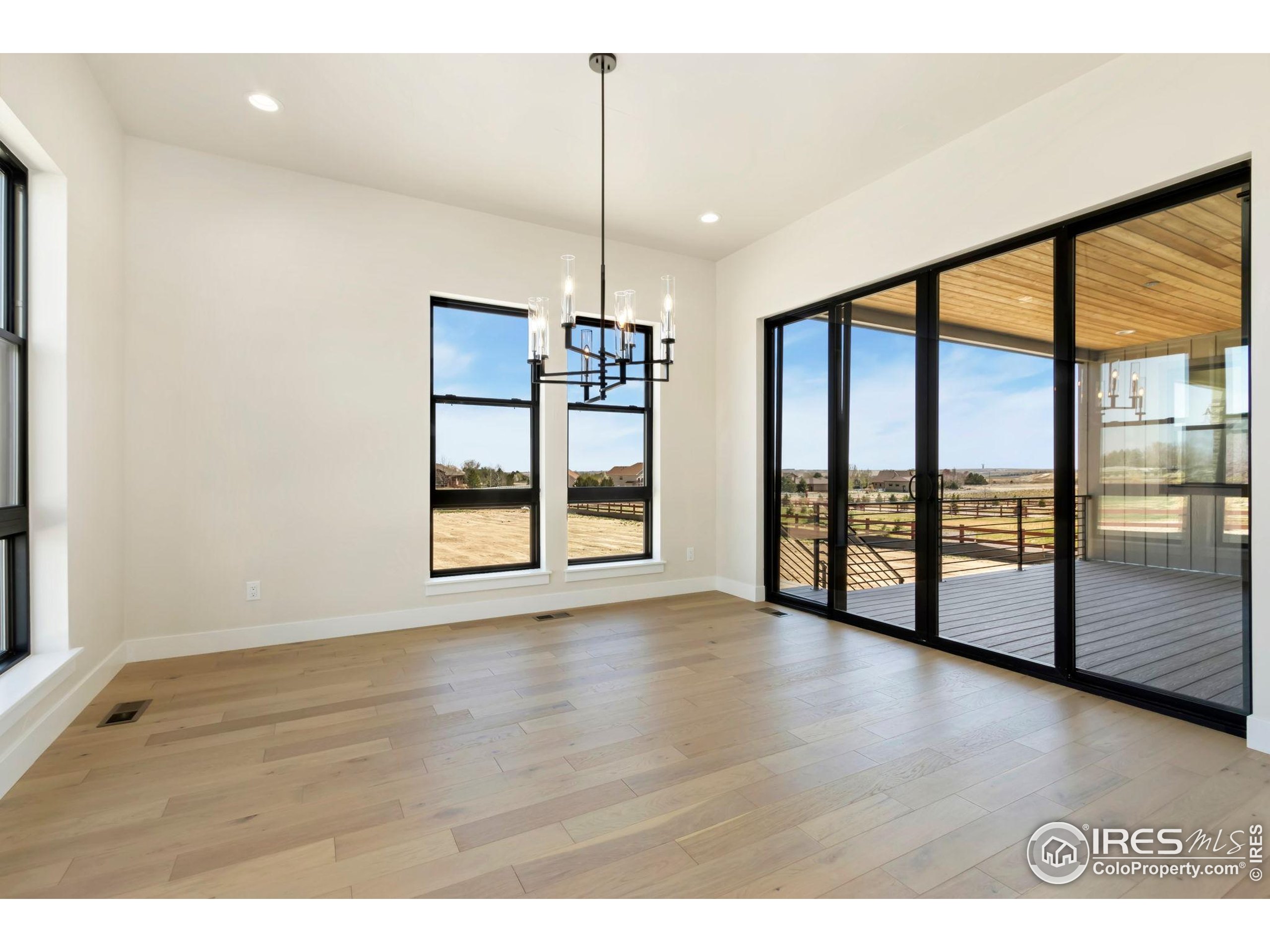 1889 Spring Bloom Drive Windsor, CO 80550 - Photo 5 of 32 a view of an empty room with window and wooden floor