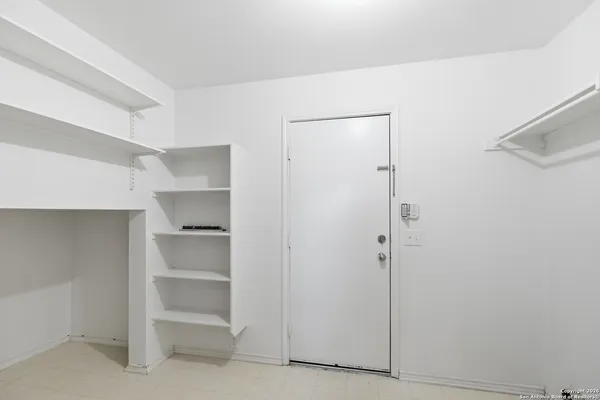 a view of walk in closet with empty racks