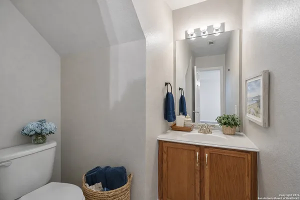 a bathroom with a sink vanity mirror and toilet