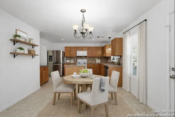a view of a dining room with furniture a rug and wooden floor