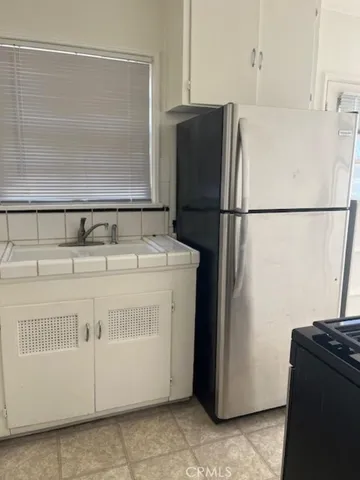 a white refrigerator freezer and a stove sitting inside of a kitchen