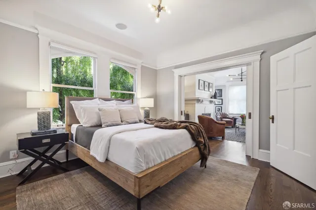 a bedroom with a bed wooden floor and window