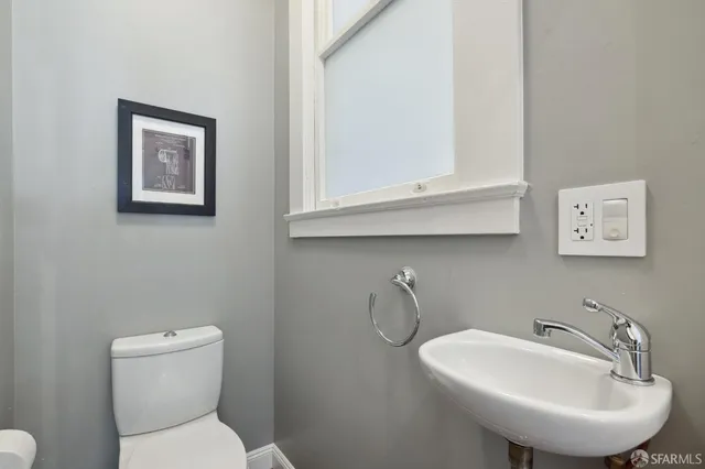 a bathroom with a toilet a sink and mirror