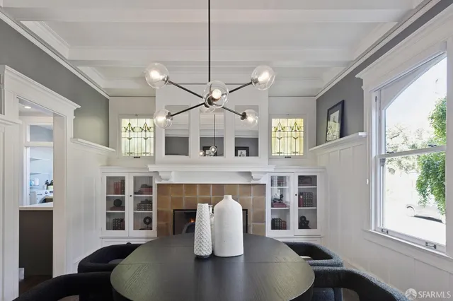 a living room with couches a dining table and kitchen view with wooden floor