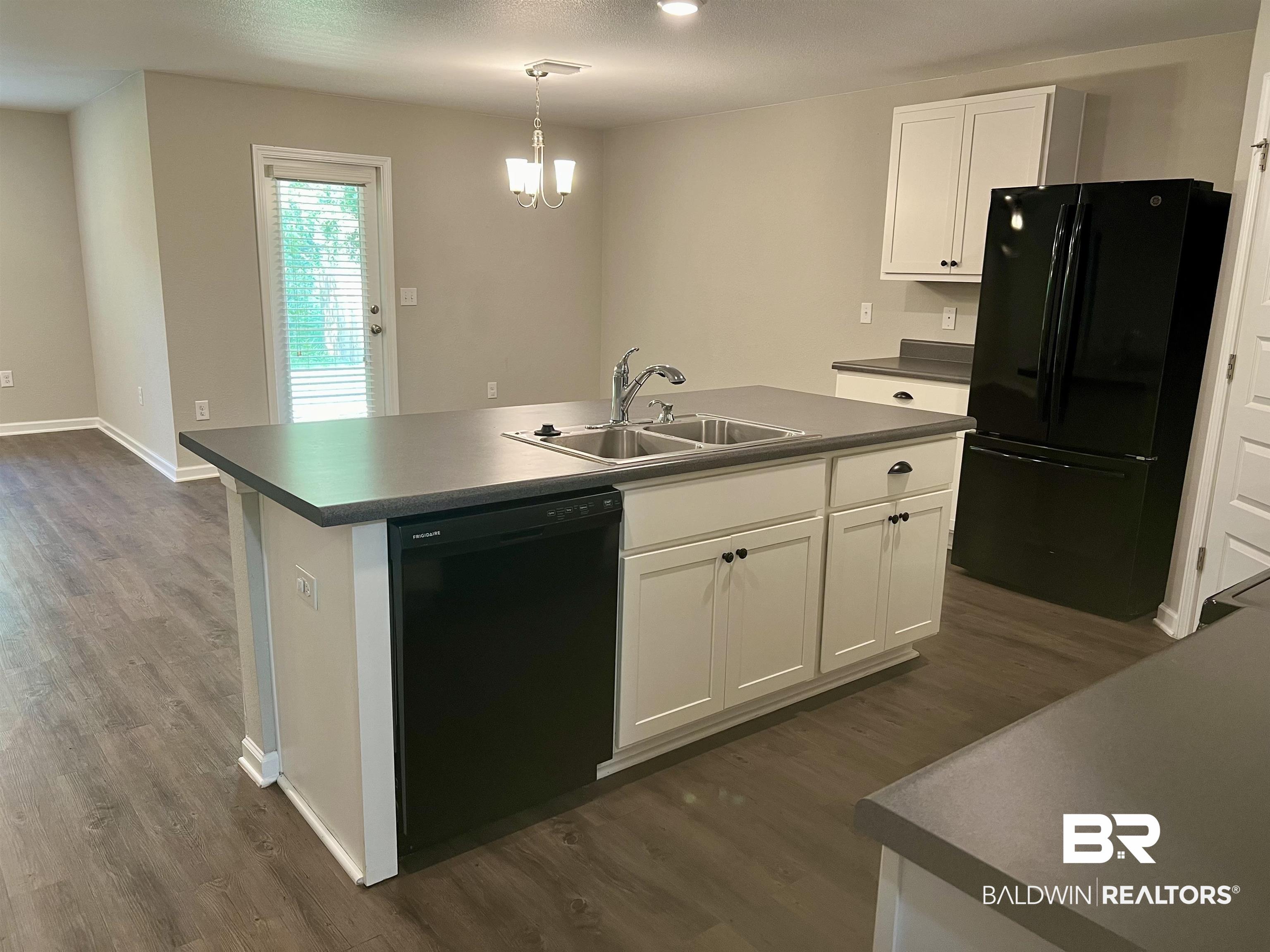 1612 Abbey Loop Foley, AL 36535 - Photo 9 of 30 Kitchen with a center island with sink, dark wood-type flooring, black appliances, and sink
