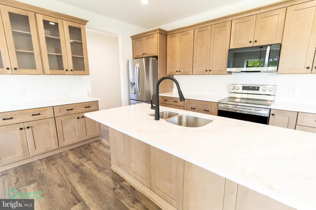 a view of a refrigerator in kitchen and an empty room